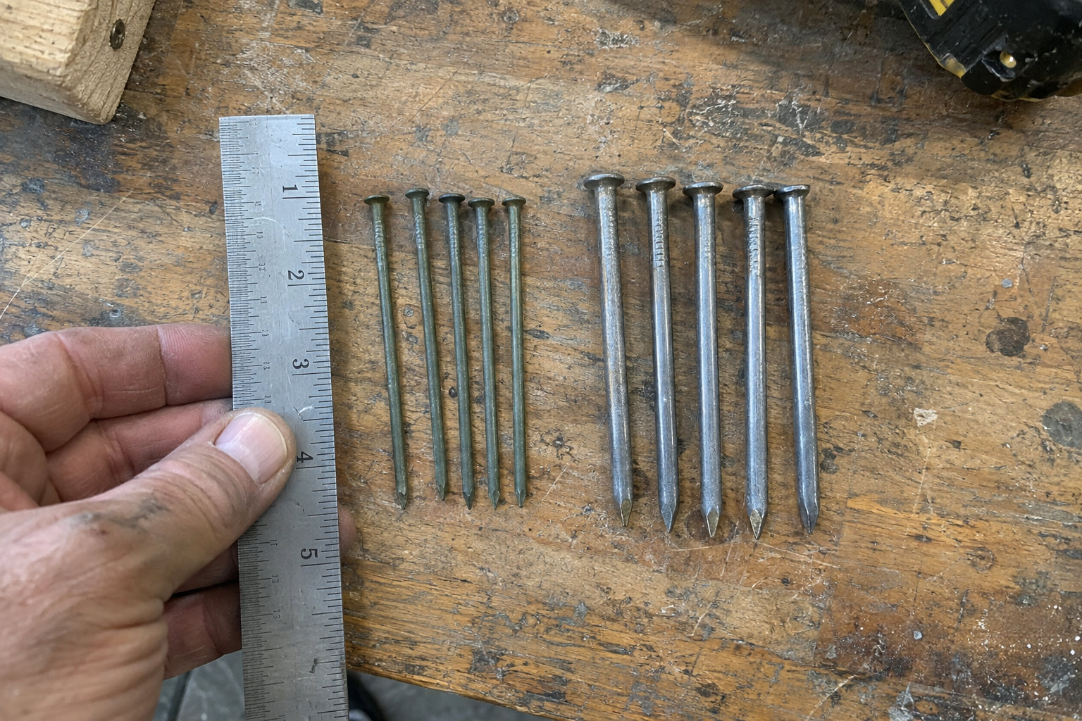 sinker nails vs common nails comparison on wooden surface